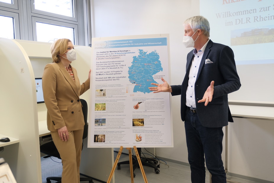Zeigt großes Interesse: Bundesministerin Julia Klöckner, die sich von Prof. Dr. Ulrich Fischer (DLR Rheinpfalz) über die FEI-Forschungsaktivitäten im Rahmen der Industriellen Gemeinschaftsforschung (IGF) informieren lässt.