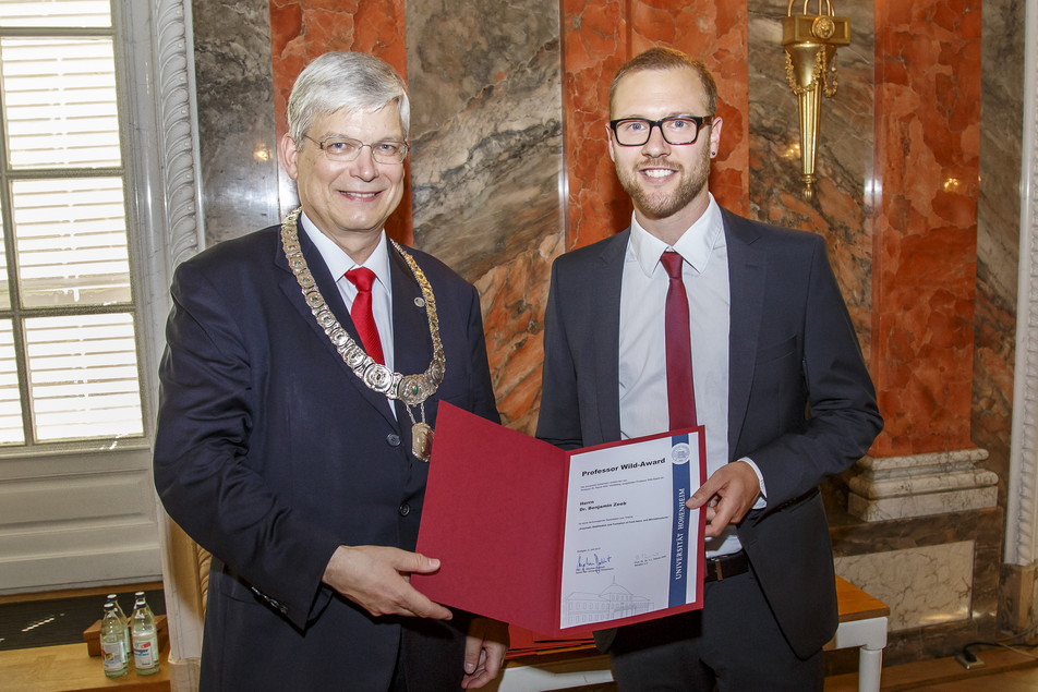 Der Rektor der Universität Hohenheim, Prof. Dr. Stephan Dabbert überreicht Dr. Benjamin Zeeb den Professor Wild-Award.