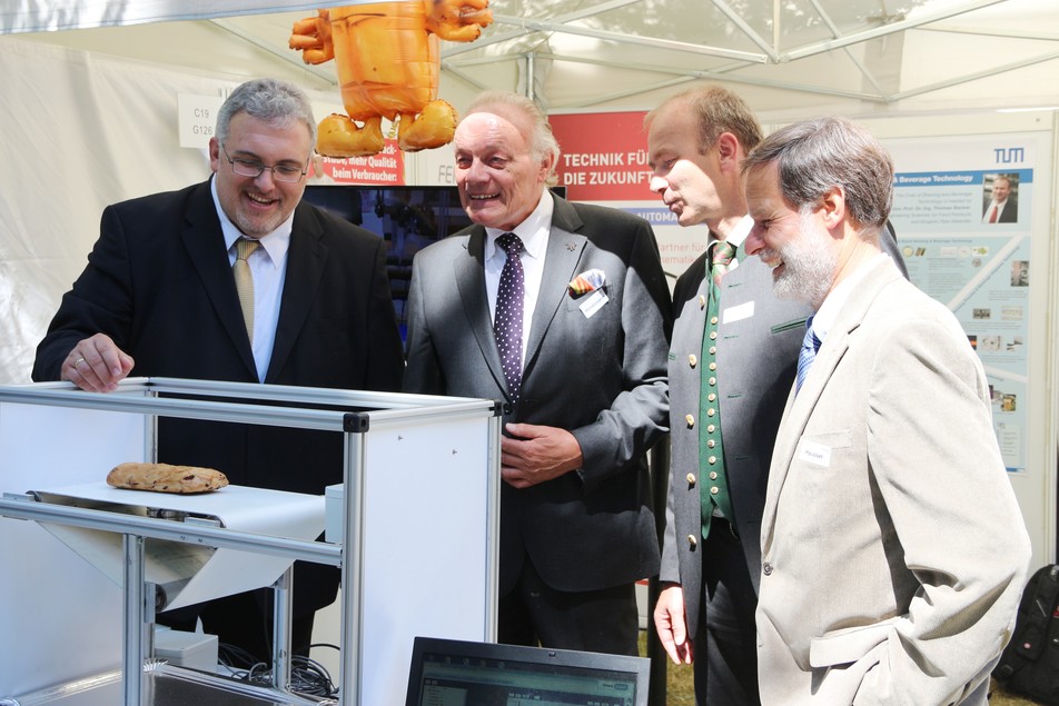 MdB Erich Irlstorfer lässt sich das Exponat zur Ultraschall-Technologie genau erklären: Von Jürgen Horstmann, Geschäftsführer der HorstmannGroup, Prof. Thomas Becker, Lehrstuhlinhaber an der TU München sowie Dr. Volker Häusser, Geschäftsführer des FEI.