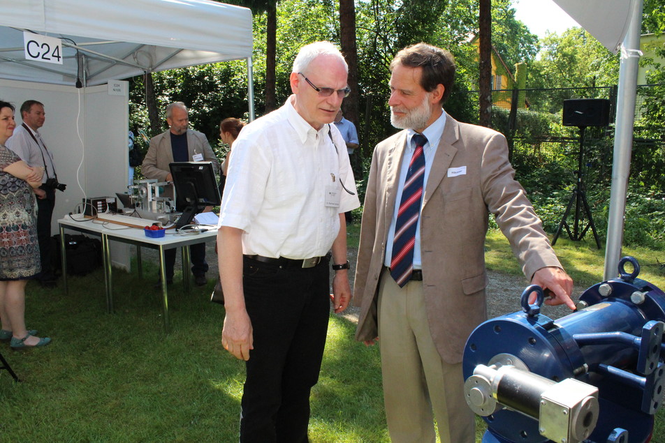 Dr. Volker Häusser, Geschäftsführer des FEI, hier rechts im Bild, demonstriert Dr. Reinhard Jensch vom BMWi die Funktionsweise des ausgestellten Extruders.