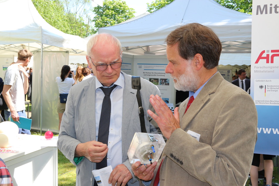 Dr. Reinhard Jensch vom BMWi lässt sich von FEI-Geschäftsführer Dr. Volker Häusser die Funktionsweise der Dekontaminationseinheit erklären.