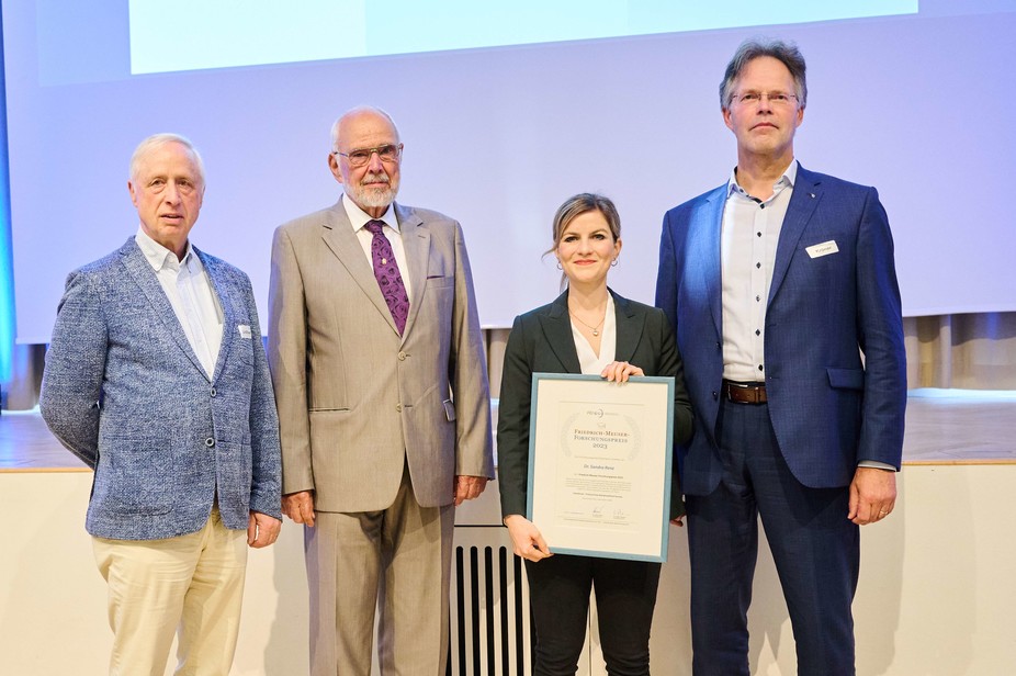 Ausgezeichnet für ihre herausragende Dissertation zum Thema Hybridmeat: Dr. Sandra Renz mit der Urkunde, die ihm zuvor der FEI-Vorsitzende Dr. Götz Kröner (rechts) überreicht hat. Erste Gratulanten sind Prof. Dr. Meinolf Lindhauer der Fachjury sowie der Namensgeber des Preises, Prof. Dr. Dr. Friedrich Meuser (v. l.)